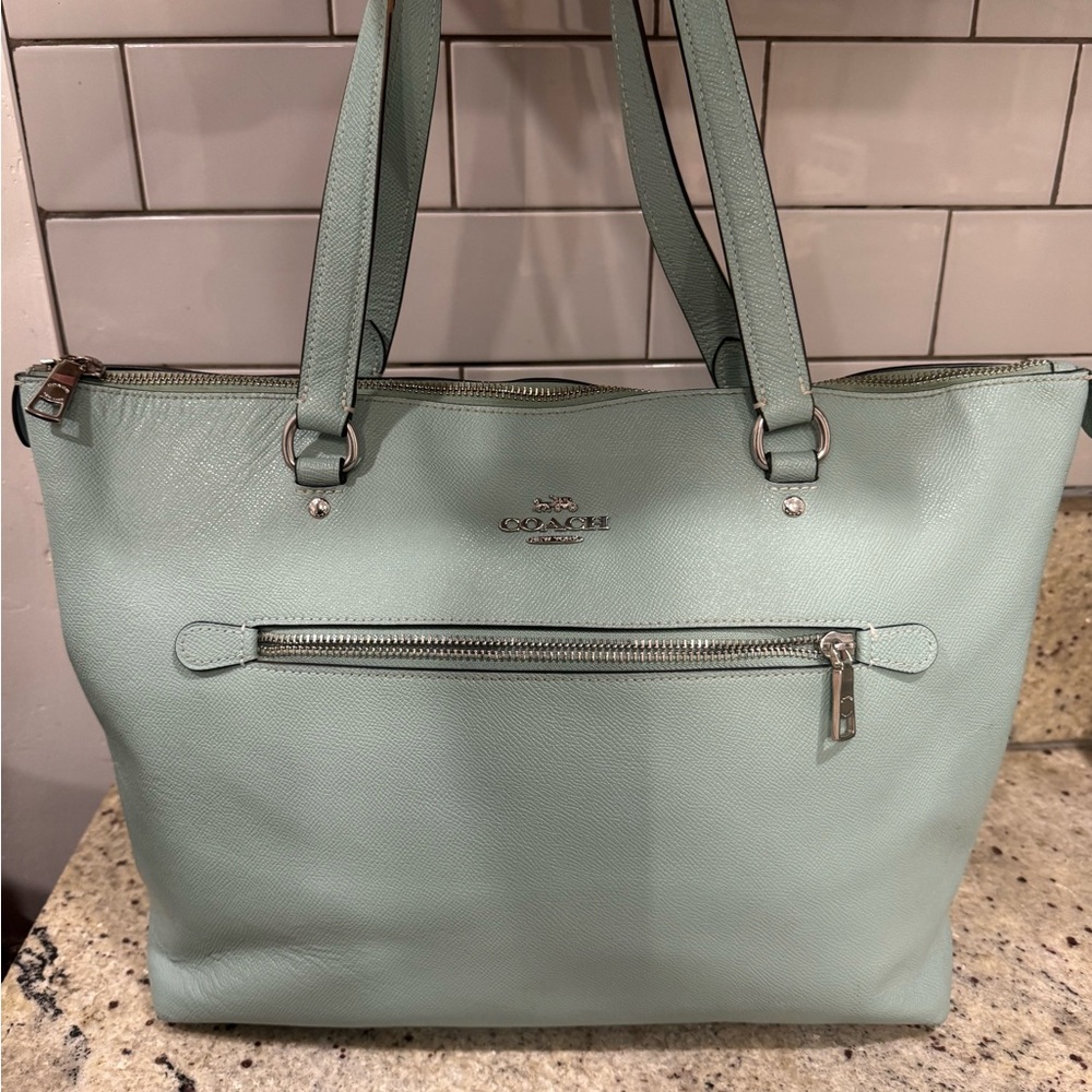 Coach mint green leather tote bag with zipper closure and two interior pockets